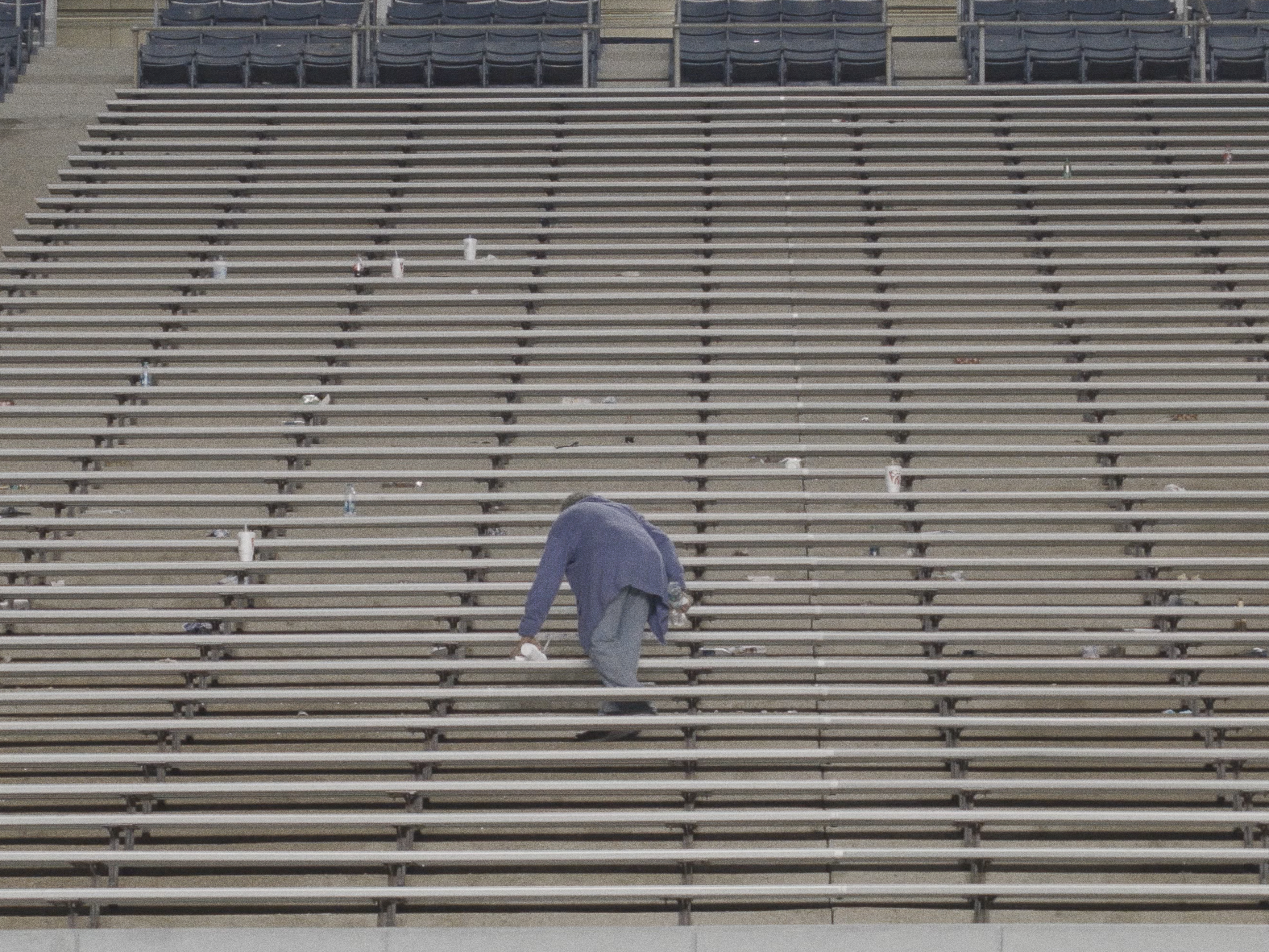 Still of a person cleaning stadium seating.
